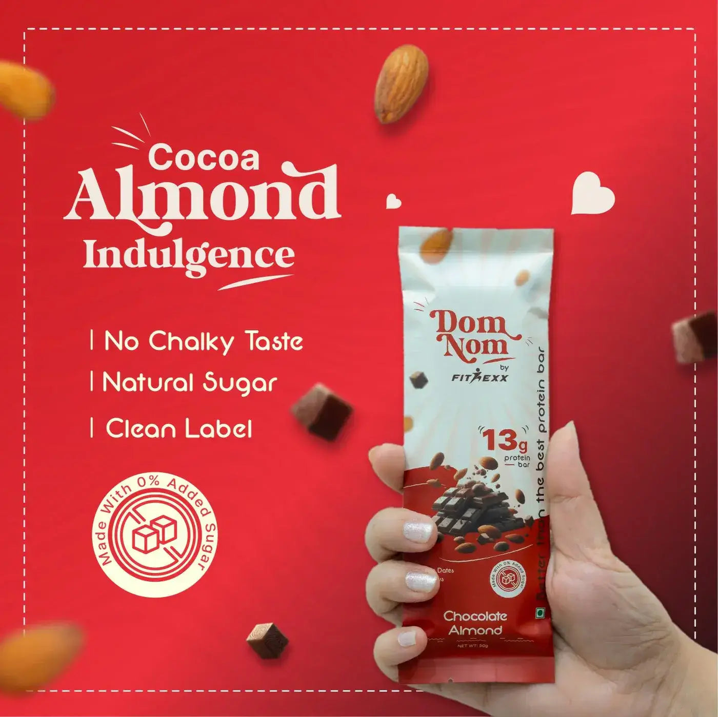 Dom Nom Cocoa Almond Protein Bar - A delicious and nutritious protein bar with 13g protein, natural sugar, and no chalky taste. Made with 0% added sugar, featuring a clean label for a guilt-free snack. Hand holding the vibrant pink packaging against a berry-themed background