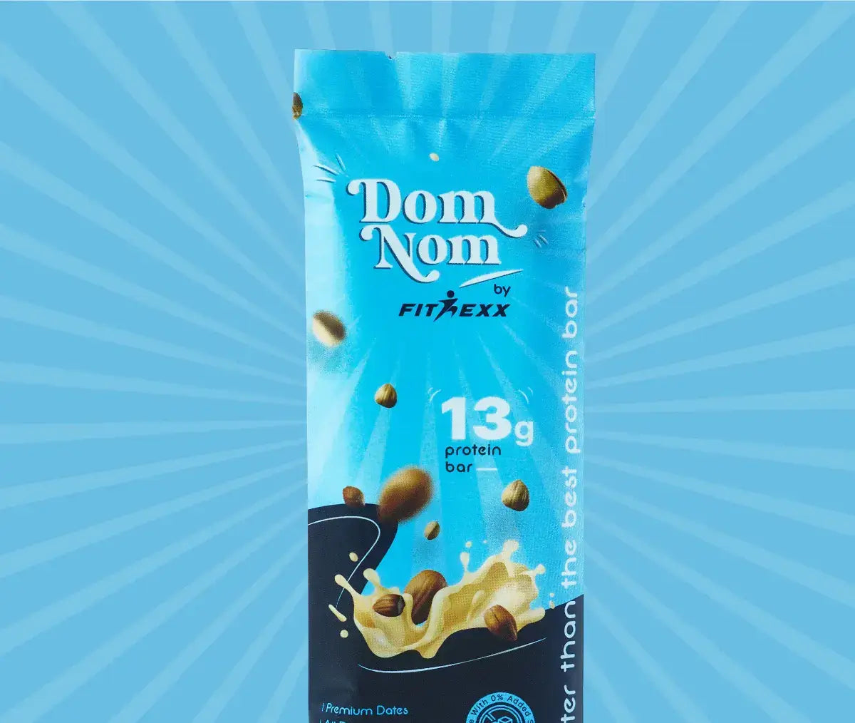 Dom Nom protein bar by Fitnexx in blue packaging, featuring 13g protein, premium dates, and a nutty milk splash design